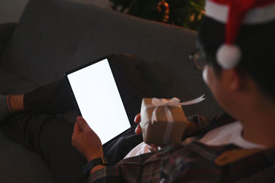 Rear view of man and woman using mobile phone