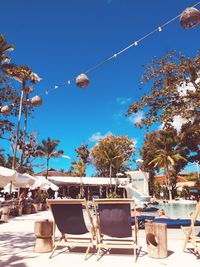 Empty chairs and tables against blue sky