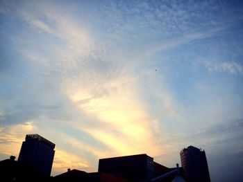 Low angle view of buildings against sky at sunset