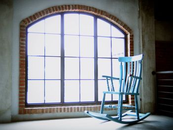 Blue rocking chair by window