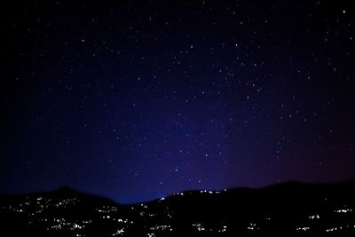 Low angle view of silhouette mountain against sky at night