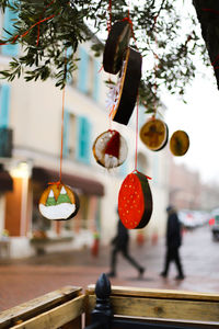 Close-up of electric lamp hanging on metal in city