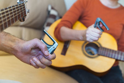 People preparing guitar in home