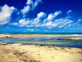 Scenic view of beach against blue sky
