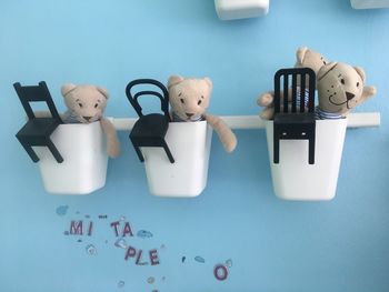 Close-up of teddy bears and chair toys in container on wall