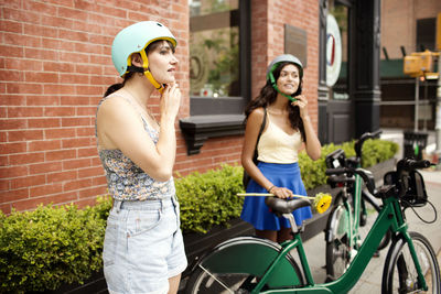 Friends wearing helmet at sidewalk cafe