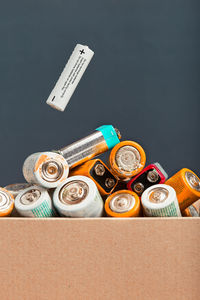 Close-up of battery in container against colored background