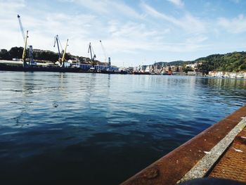 Boats moored at harbor against sky