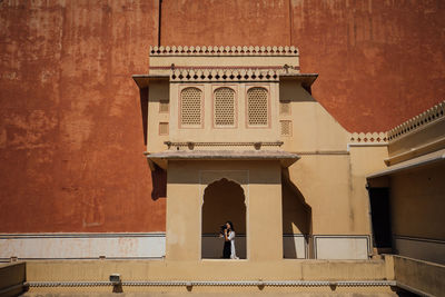 Rear view of woman photographing at historic building 