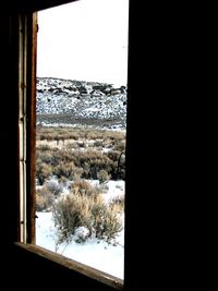 Snow covered landscape seen through window