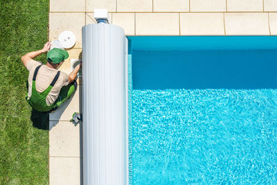 High angle view of man working by swimming pool