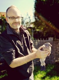Portrait of man holding bird