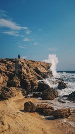 Rock formation on beach against sky