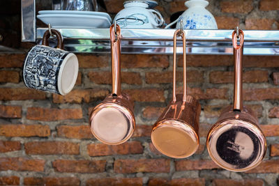 Close-up of kitchen utensils hanging from railing