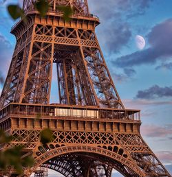 A shot of eiffel tower with the moon at early sunset