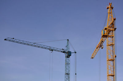 Low angle view of crane against clear sky