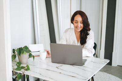 Young woman using laptop at home