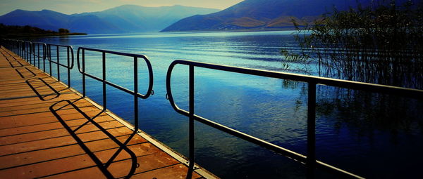 Scenic view of lake by mountains against sky