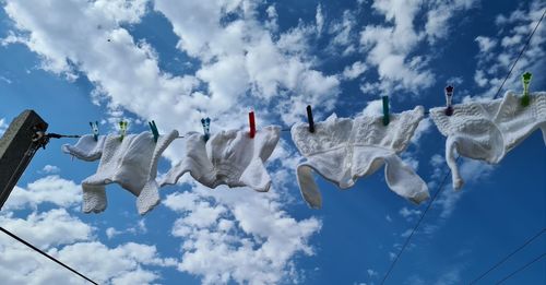 Low angle view of flags hanging against sky