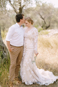 Rear view of bride standing on field