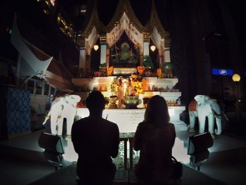 Rear view of people standing in temple