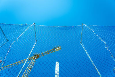 Low angle view of barbed wire against clear blue sky