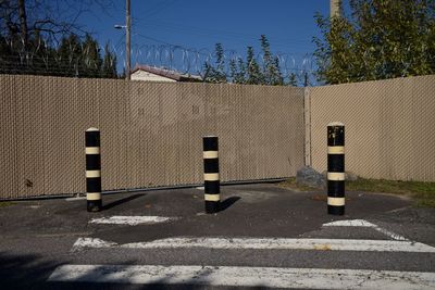 Road by fence against sky