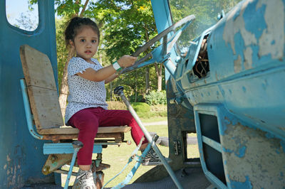 Full length of boy sitting on seat