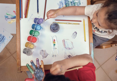 Children playing in an inner courtyard and painting with water paints