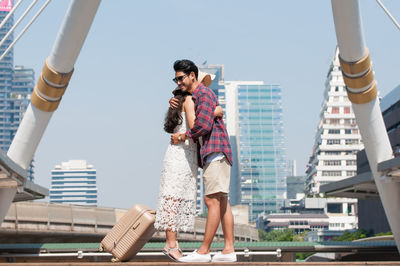 Full length of friends standing in city against clear sky