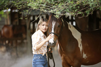 Portrait of teenage girl standing in stable