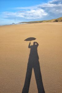 Shadow of man on sand dune in desert
