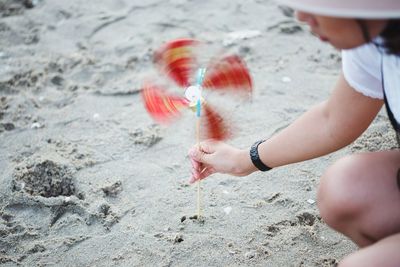 Woman holding pinwheel toy at beach