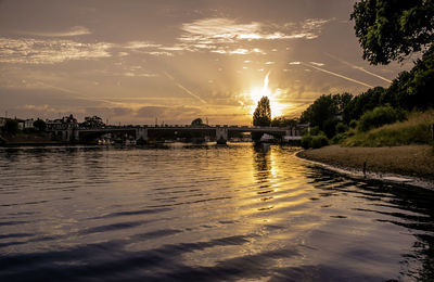 Scenic view of river against sky at sunset