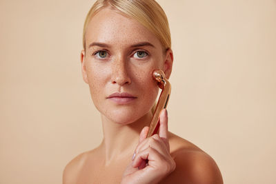 Portrait of young woman with eyes closed against pink background