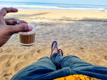 Low section of man having tea at beach