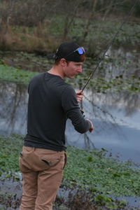 Side view of man fishing in water