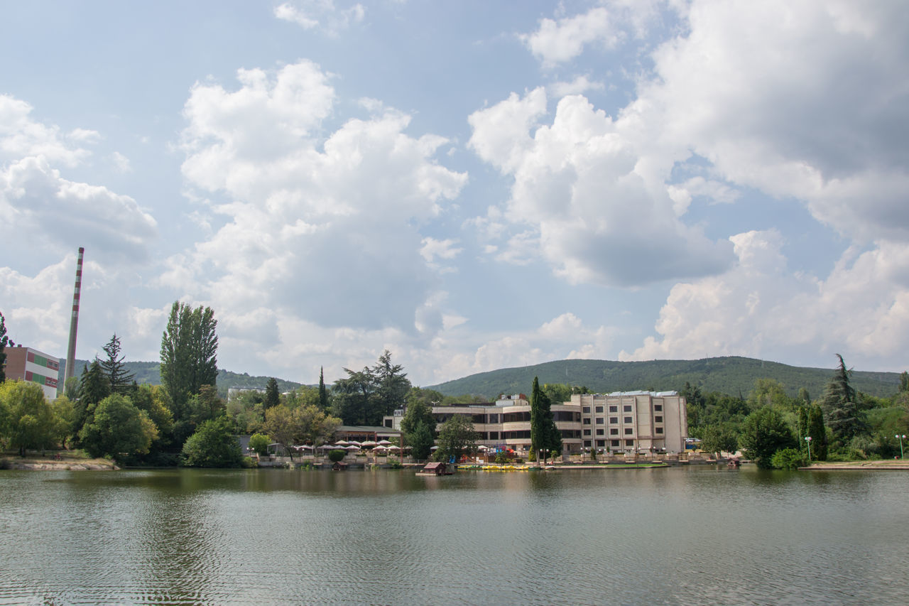 BUILDING BY LAKE AGAINST SKY