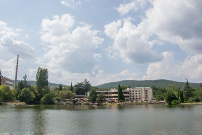 Scenic view of lake by buildings against sky