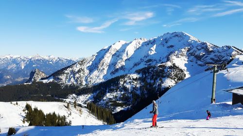 Two people skiing on snowcapped mountain against sky