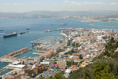 High angle view of townscape by sea against sky