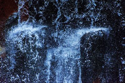 Close-up of water splashing against black background