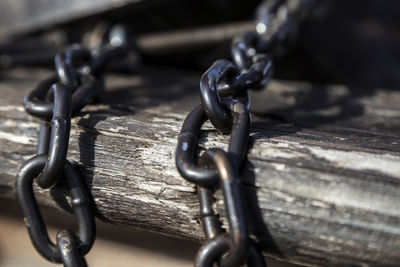 Close-up of rope tied on metal chain