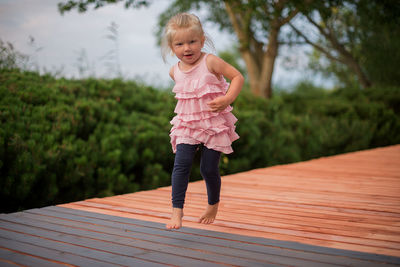 Full length portrait of girl jumping on floorboard