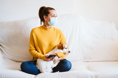 Young woman sitting on sofa at home