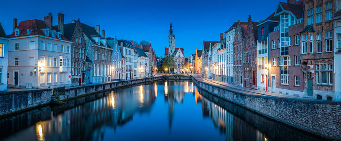 Panoramic view of canal amidst buildings in city at dusk