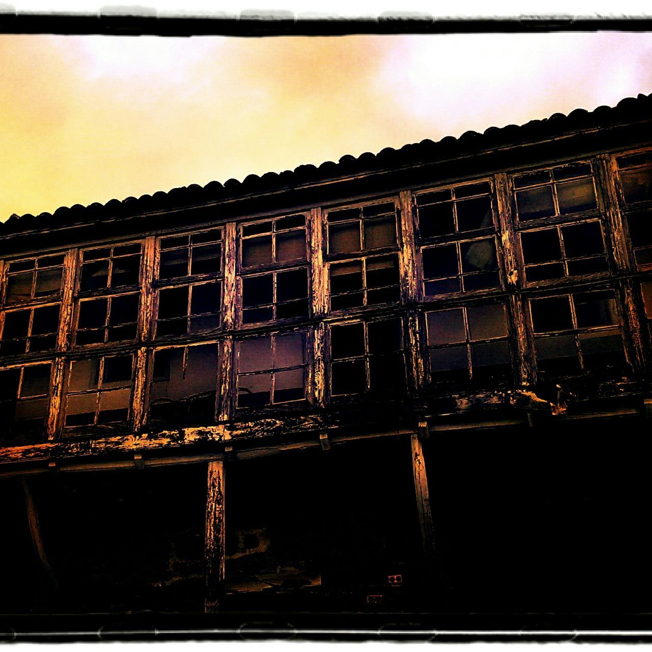 architecture, built structure, building exterior, sky, window, auto post production filter, low angle view, transfer print, house, building, no people, outdoors, abandoned, residential structure, reflection, sunset, metal, residential building, old, damaged