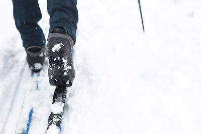 Low section of person standing on snow covered land