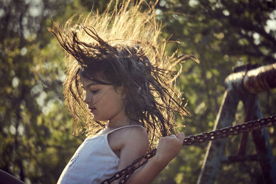 Side view of girl on swing