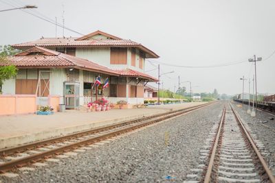 Railroad station by building against clear sky